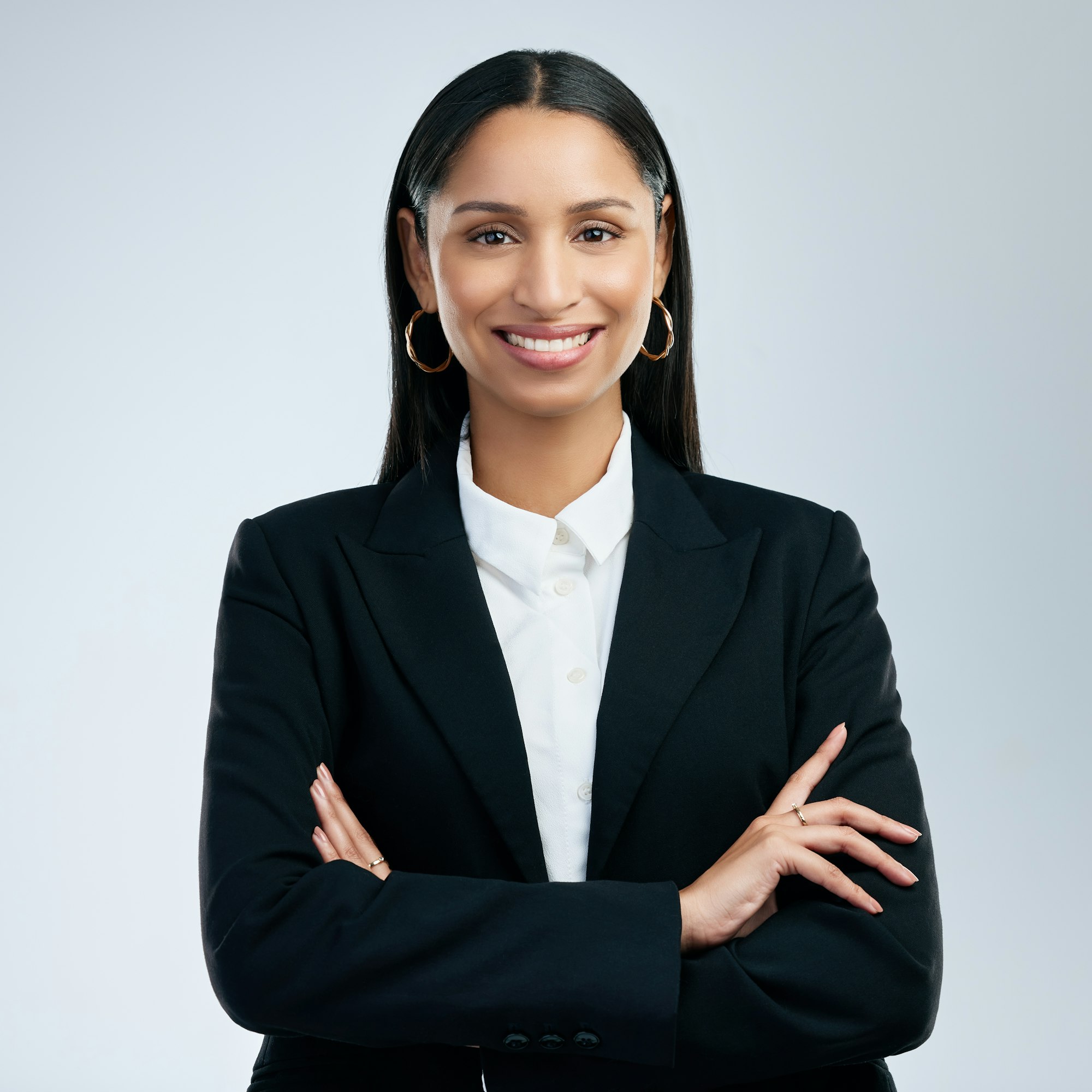 shot of a confident young businesswoman standing against a grey background.jpg